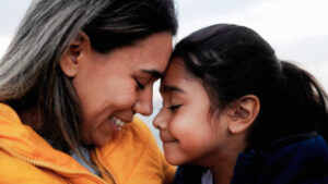 A mother reassuring her child with a gentle hug, symbolizing parental support in trauma recovery.