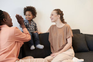 A trauma therapist supporting a child and parent in a comforting therapy environment.