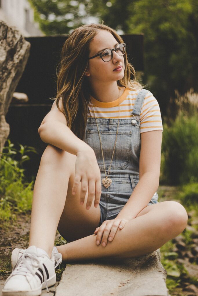 Photo of a young girl sitting outside thinking. Don't let your depression symptoms take over. Learn to manage your symptoms in a healthy way with the help of depression counseling in Macon, GA.
