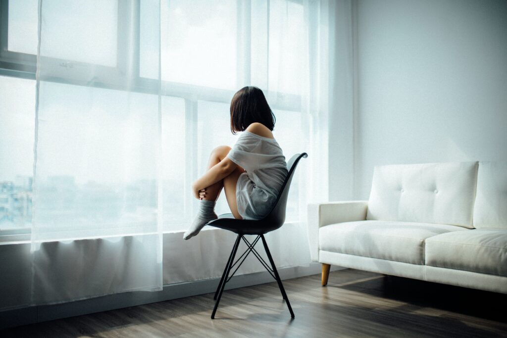 Photo of a little girl sitting in a chair hugging her knees. Is your child struggling to get past their unresolved trauma? With trauma therapy in Macon, GA begin to see the positive changes in them.