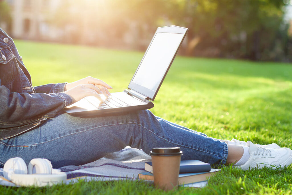 Image of a woman sitting in the grass using a laptop. Struggling to find the time to go to therapy? Learn how online therapy in Utah can be effective and help you manage your anxiety, depression, and more.