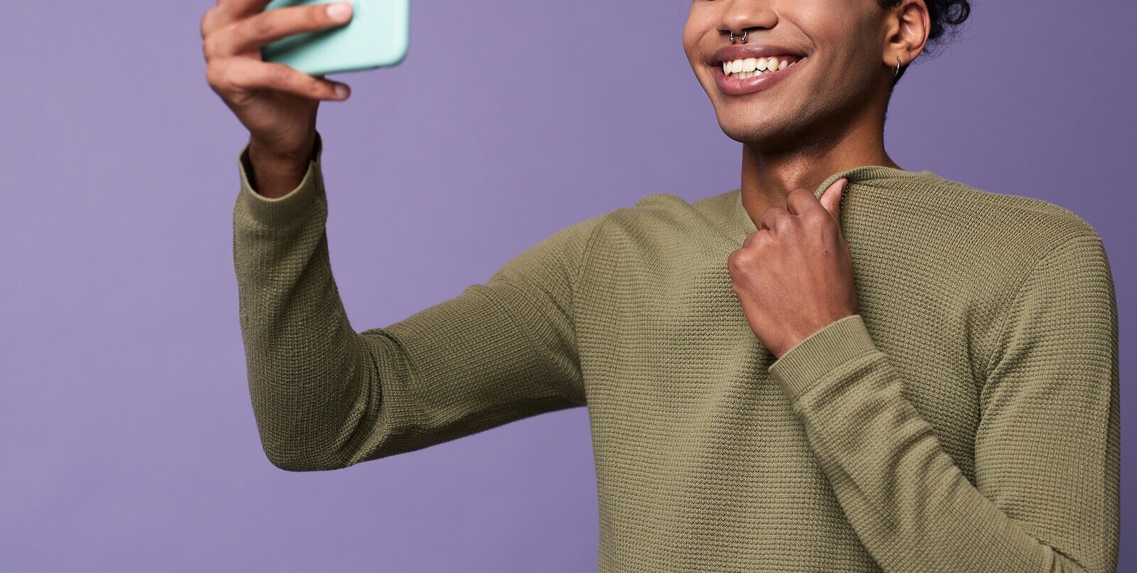 Image of a young teen holding up a cell phone and smiling at it. Is your teen's mental health being affected by social media? Learn to support their mental health with teen counseling in Macon, GA.