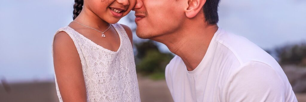Image of a smiling man pressing his nose against his smiling daughters face. If you struggle with parenting you can find support with the help of PCIT therapy in Macon, GA.