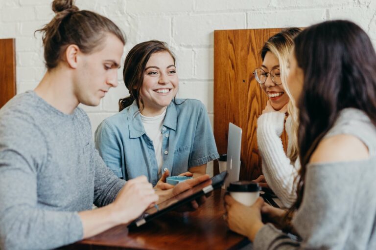 Photo of a happy and chatty group of friends sitting at a table. With the help of life transition counseling in Macon, GA you can begin learning to manage big changes in healthy and positive ways.