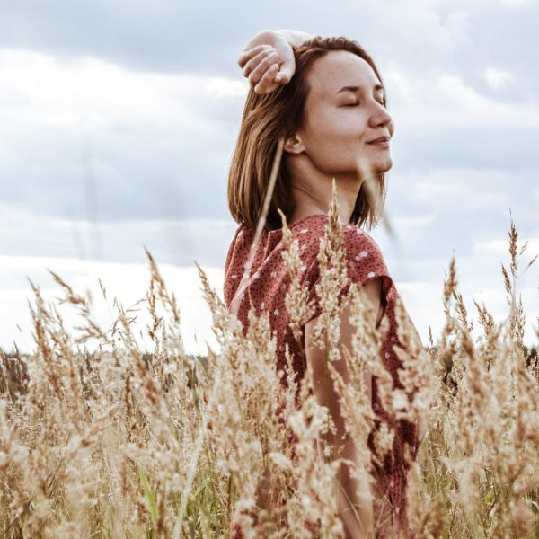 Photo of a smiling carefree woman in a field. Find help managing your depression or anxiety with the help of therapy for adults in Macon, GA.