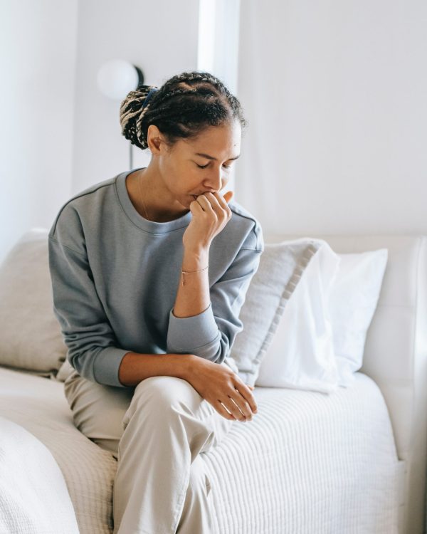 Photo of a woman sitting on a chair with her head in her hand. Discover how therapy for adults in Macon, GA can help you explore your thoughts in feelings in a a healthy way.