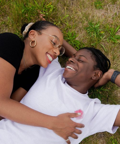 Couple happily laying on the ground smiling. Looking for new ways to bond with your partner? Begin working with a couples therapist in couples therapy in Macon, GA to explore new ways to bond with your partner.