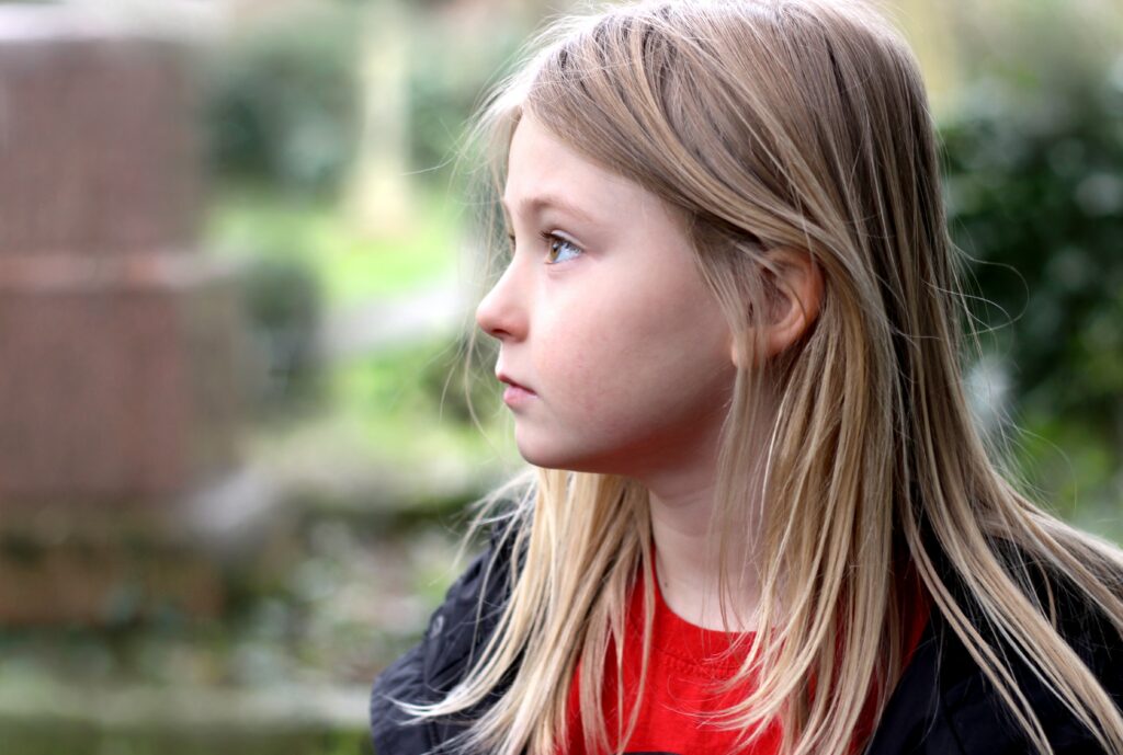 Photo of a child sitting outside. Trauma symptoms can be hard to manage. Discover how brainspotting therapy in Macon, GA can help you begin working through your symptoms and manage them effectively.