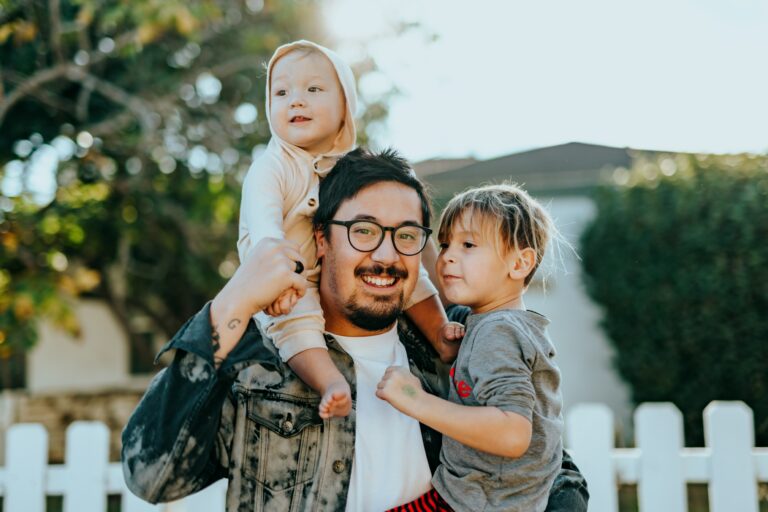 Photo of a smiling man holding two children. Do you and your family struggle with supporting each other? Learn how family counseling in Macon, GA can help create better connections!