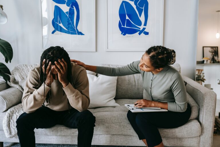 Photo of a therapist putting a hand on a man's shoulder to comfort him. Are you struggling with past trauma? Discover how trauma therapy in Macon, GA can help you overcome your struggles.