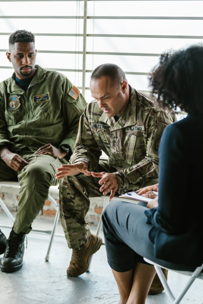 Photo of upset military members sitting in a support group. Learn to overcome and manage your PTSD in a healthy way with the help of PTSD therapy in Macon, GA.
