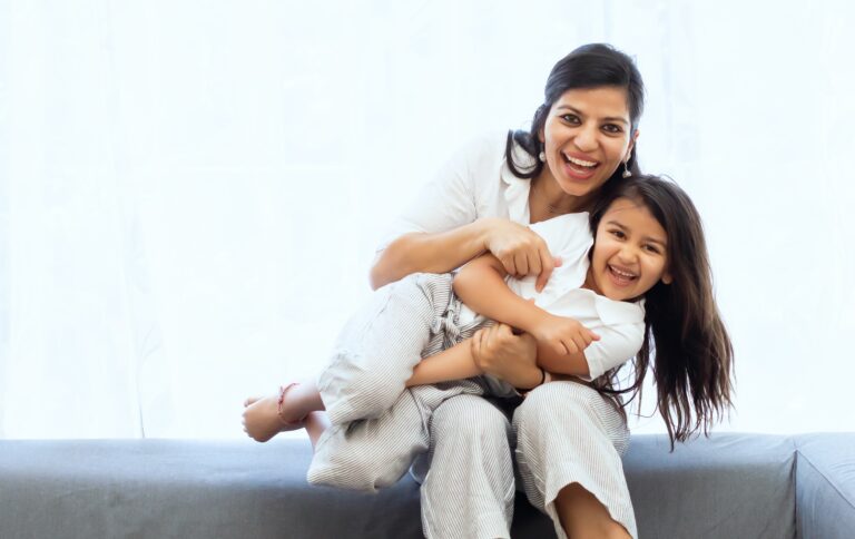 Photo of a mother tickling her daughter and smiling. Discover how the help of a family therapist in family counseling in Macon, GA can help your family connect easily and help with arguments.